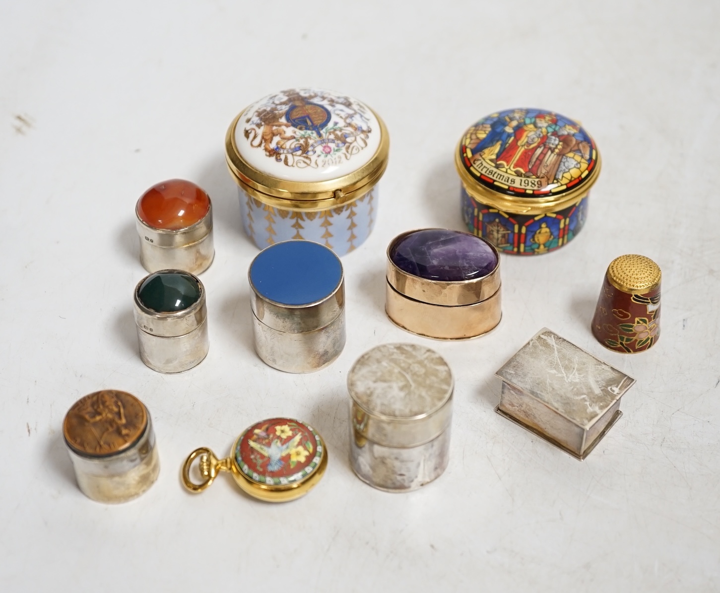 A collection of patch boxes including some silver, a gilt metal and amethyst example, Halcyon Days enamel and a miniature yellow metal love heart locket stamped 375, largest 4.5cm diameter. Condition - mostly good